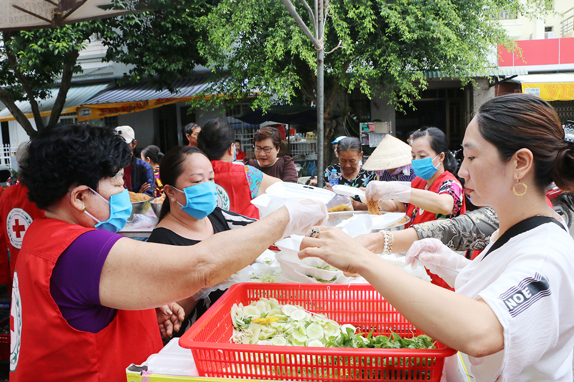 Tình nguyện viên bếp ăn tình thương thuộc Hội Chữ Thập đỏ Vòng Tay Nhân Ái phát cơm miễn phí cho người có hoàn cảnh khó khăn trên địa bàn TP. Rạch Giá.